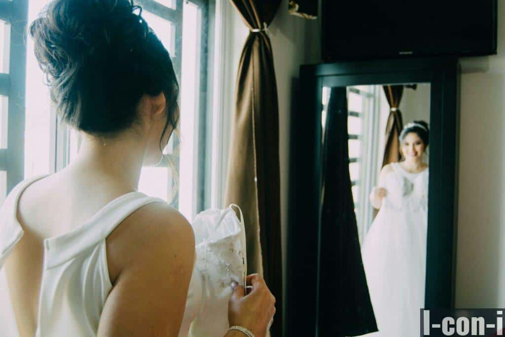 Woman in White Sleeveless Dress Holding a Bridal Gown